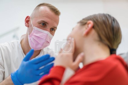 Téléchargez les photos : Contrariée patiente au rendez-vous chez le dentiste se plaint de maux de dents et de caries tenant ses joues cabinet dentaire - en image libre de droit