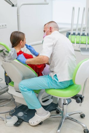 Photo for The patient at the dentist's appointment complains of toothache and caries the doctor advises her before  examination - Royalty Free Image