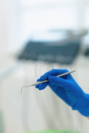 Foto de Odontólogo profesional sostiene herramientas de trabajo sonda dental en la mano enguantada antes del procedimiento clínica de cerca - Imagen libre de derechos