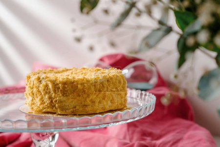 Téléchargez les photos : Délicieux gâteau napoléon feuilleté fraîchement fait sur support en verre fond rose vif concept de dessert close-up - en image libre de droit