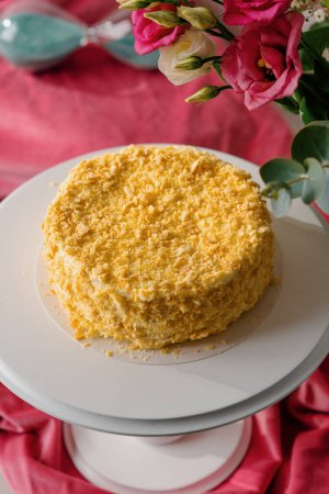 Téléchargez les photos : Délicieux gâteau napoléon feuilleté fraîchement préparé sur un stand blanc sur fond lumineux concept de dessert close-up - en image libre de droit