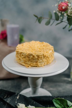 Photo for Freshly made delicious puff pastry napoleon cake on a white stand on background of flowers dessert concept - Royalty Free Image