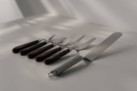 Téléchargez les photos : Différents types de spatules pâtissières ustensiles de cuisine pour gâteaux sur la table sur fond blanc close-up - en image libre de droit