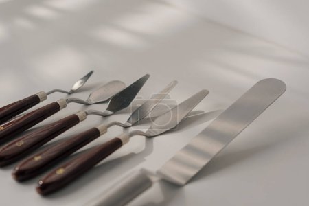 Téléchargez les photos : Différents types de spatules pâtissières ustensiles de cuisine pour gâteaux sur la table sur fond blanc close-up - en image libre de droit