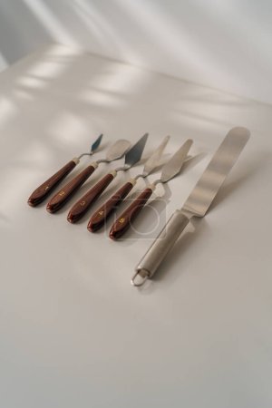Téléchargez les photos : Différents types de spatules pâtissières ustensiles de cuisine pour gâteaux sur la table sur fond blanc - en image libre de droit