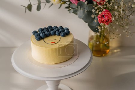 Photo for Delicious freshly prepared biscuit bento cake decorated with berries stands on a stand on white background with flowers - Royalty Free Image