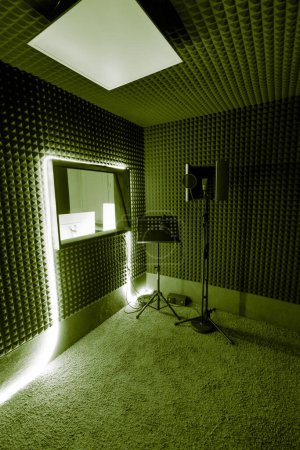 Foto de Estudio de grabación vacío con equipo profesional soporte de micrófono ingeniero de sonido ventana luz de neón amarillo - Imagen libre de derechos