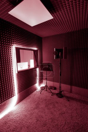 Foto de Estudio de grabación vacío con equipo profesional soporte de micrófono ingeniero de sonido ventana luz de neón roja - Imagen libre de derechos