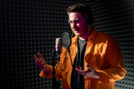 Téléchargez les photos : Jeune artiste pop rap enregistrement émotionnel nouvelle chanson studio d'enregistrement professionnel chantant avec microphone - en image libre de droit