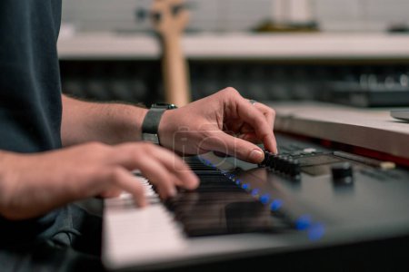 Téléchargez les photos : Studio d'enregistrement professionnel ingénieur du son producteur de musique musicien appuyant sur les touches synthétiseur - en image libre de droit