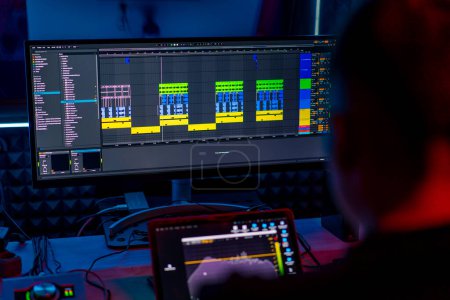 Foto de Estudio de grabación de sonido profesional ingeniero de sonido o productor de música sentado en las pistas de mezcla de control remoto en la pantalla de luz de neón - Imagen libre de derechos