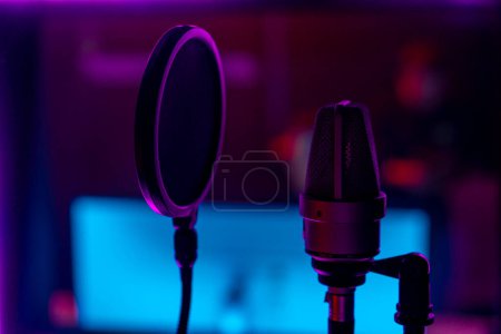 Téléchargez les photos : Professionnel enregistrement studio chanson matériel d'enregistrement microphone gros plan violet néon lumière - en image libre de droit