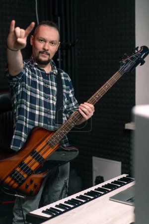 Téléchargez les photos : Portrait d'un artiste rock avec une guitare électrique dans un studio d'enregistrement tient un instrument de musique ses mains cordes mélodie - en image libre de droit