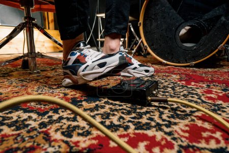 Foto de El pie del hombre presionando el pedal del bombo en el estudio de grabación batería de batería tocando en el interior primer plano - Imagen libre de derechos