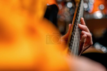 Foto de Intérprete de rock con guitarra eléctrica en grabación de estudio tocando propia pista creando cuerda de instrumentos musicales primer plano - Imagen libre de derechos
