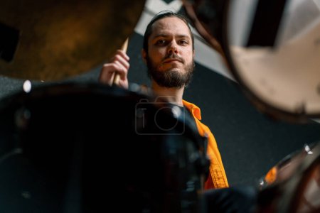 Téléchargez les photos : Un jeune batteur joue un kit de batterie dans un studio d'enregistrement lors de la répétition d'un musicien professionnel - en image libre de droit