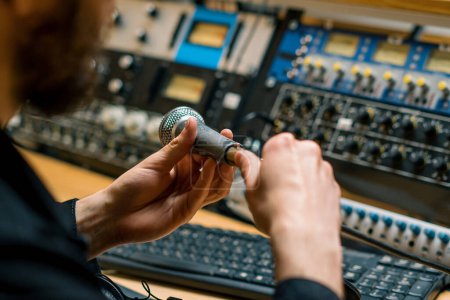 Téléchargez les photos : Ingénieur du son connecte le microphone à l'équipement de musique dans les mains de gros plan studio d'enregistrement professionnel - en image libre de droit