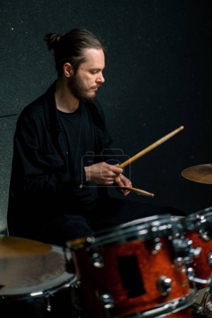 Foto de Un joven baterista toca un kit de batería en un estudio de grabación en la canción de ensayo de un músico profesional - Imagen libre de derechos