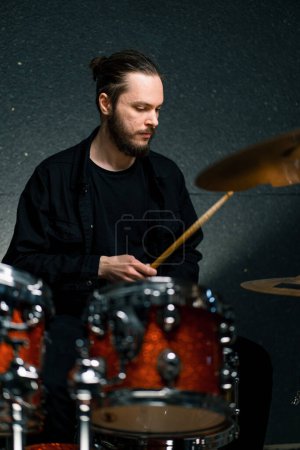Téléchargez les photos : Un jeune batteur joue un kit de batterie dans un studio d'enregistrement lors de la répétition d'un musicien professionnel - en image libre de droit