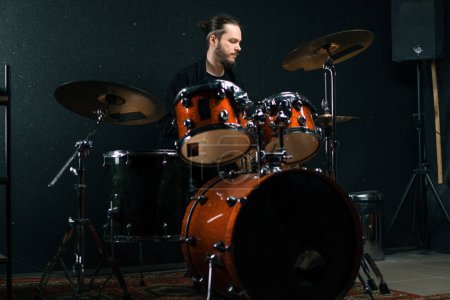 Foto de Un joven baterista toca un kit de batería en un estudio de grabación en la canción de ensayo de un músico profesional - Imagen libre de derechos