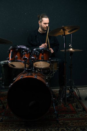 Photo for A young male drummer plays a drum kit in a recording studio at a professional musician's rehearsal recording song - Royalty Free Image