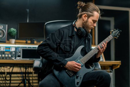 Photo for Rock performer with electric guitar in recording studio recording playing own track musical instrument strings melody - Royalty Free Image