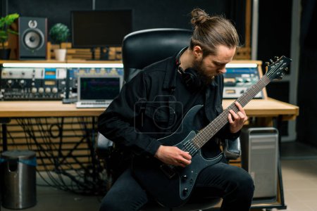 Foto de Intérprete de rock con guitarra eléctrica en estudio de grabación tocando pistas propias cuerdas de instrumentos musicales melodía - Imagen libre de derechos