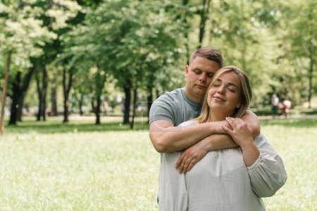 Photo for Portrait of a couple in love a man and a pregnant woman are hugging, waiting for a new addition to happy family - Royalty Free Image
