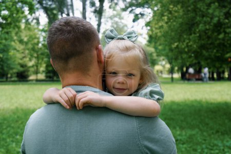 Photo for Happy family A young father holds a child in his arms Father and daughter hugging each other outdoors in park Father's Day - Royalty Free Image