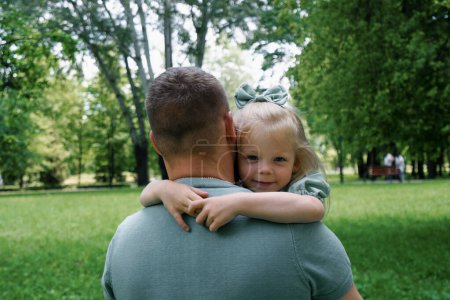 Foto de Familia feliz Un padre joven sostiene a un niño en sus brazos Padre e hija abrazándose al aire libre en el parque Día del Padre - Imagen libre de derechos