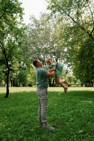 Foto de Papá juega con un niño en el parque lanza a su hija al cielo Feliz familia Día del Padre Juego familiar con niño - Imagen libre de derechos