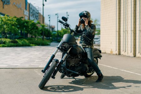 Téléchargez les photos : Brutal motard roux monte sur une moto noire avant le début de la course et met un casque convoitise pour la vitesse - en image libre de droit