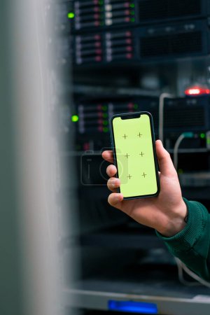 Foto de Centro de datos de primer plano hacker o ingeniero que sostiene el teléfono con pantalla verde robando información de servidores tecnología de almacenamiento en la nube - Imagen libre de derechos