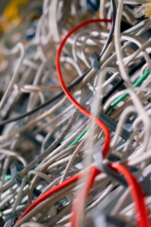 Foto de Primer plano de una pila de cables de conexión de red clasificados en un gabinete de rack que conduce desde un panel de conexión en un rack de servidor en una sala de centro de datos - Imagen libre de derechos