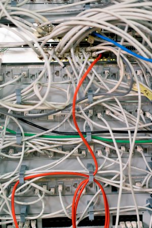 Foto de Primer plano de una pila de cables de conexión de red clasificados en un gabinete de rack que conduce desde un panel de conexión en un rack de servidor en una sala de centro de datos - Imagen libre de derechos