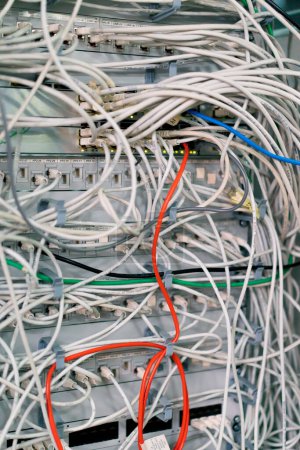 Téléchargez les photos : Gros plan d'une pile de câbles de raccordement réseau triés dans une armoire de rangement menant à partir d'un panneau de raccordement dans un rack de serveur dans une salle de centre de données - en image libre de droit