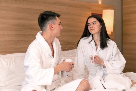 Foto de Joven pareja en luna de miel en hotel habitación teniendo desayuno habitación beber café feliz amantes viaje concepto - Imagen libre de derechos