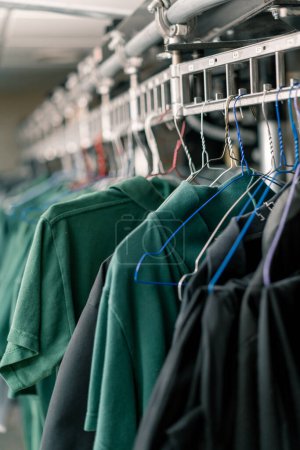 Téléchargez les photos : Blanchisserie industrielle dans l'hôtel chemises propres des employés et des clients triés après lavage accrocher sur les cordes à linge concept propreté et hospitalité - en image libre de droit
