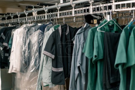 Photo for Industrial laundry in the hotel clean shirts of employees and guests sorted after washing hang on clotheslines concept cleanliness and hospitality - Royalty Free Image