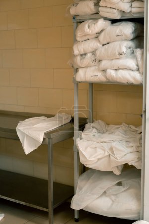 Téléchargez les photos : Blanchisserie industrielle dans les serviettes de l'hôtel et le linge de lit sur les étagères triées après lavage concept de propreté et d'hospitalité - en image libre de droit