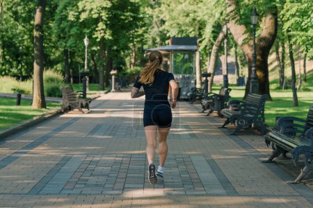Téléchargez les photos : Fitness jeune fille sportive faisant du sport le matin courir pendant l'entraînement en plein air dans la ville dans le parc concept de mode de vie sain - en image libre de droit