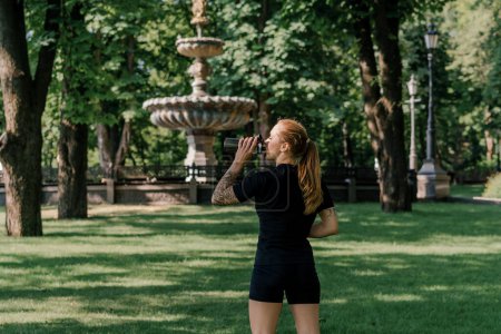 Photo for Portrait of young satisfied sports girl drinking water outdoors after training park healthy lifestyle concept - Royalty Free Image