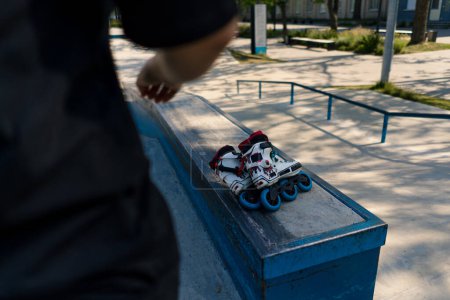 Téléchargez les photos : Patins à roulettes se trouvent sur le terrain de sport dans le skate park avant le début de l'équipement de sport de rue - en image libre de droit