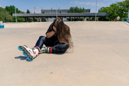 Photo for Upset girl crying after falling on rollers on roller rink unsuccessful skating injury active recreation hobby - Royalty Free Image