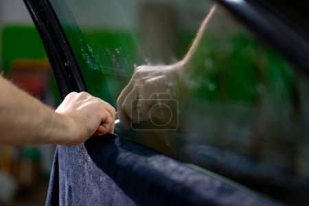 Foto de Hombre servicio de coches pegamento ventana teñido en coche de lujo detallando reparación de automóviles el concepto de amor por los coches y la protección - Imagen libre de derechos