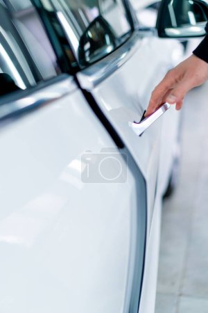 Photo for A man opens the door of his luxury white car after detailing and dry cleaning at car service - Royalty Free Image