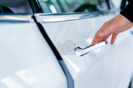 Foto de Un hombre abre la puerta de su lujoso coche blanco después de detallar y limpiar en seco en el servicio de automóviles - Imagen libre de derechos