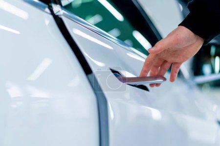 Téléchargez les photos : Un homme ouvre la porte de sa voiture blanche de luxe après les détails et le nettoyage à sec au service de voiture - en image libre de droit