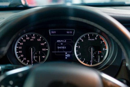 Photo for Close-up of the odometer and dashboard of a luxury car with a black interior after detailing and washing at car service - Royalty Free Image