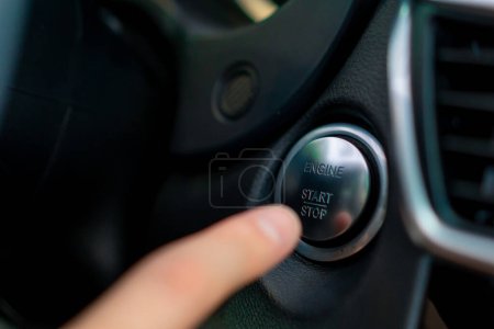 Téléchargez les photos : Homme appuie sur le bouton de démarrage de sa voiture de luxe noir intérieur de voiture - en image libre de droit